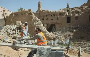  ?? AP ?? Workers restore the Al Sarreha Mosque in the Diriyah fortified complex that once served as the seat of power for the Saudi ruling family in Riyadh.