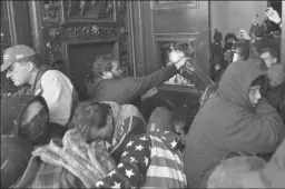  ?? TASOS KATOPODIS/GETTY IMAGES ?? Rioters smash a window and attempt to push past police officers at the U.S. Capitol on Jan. 6 in Washington, D.C.