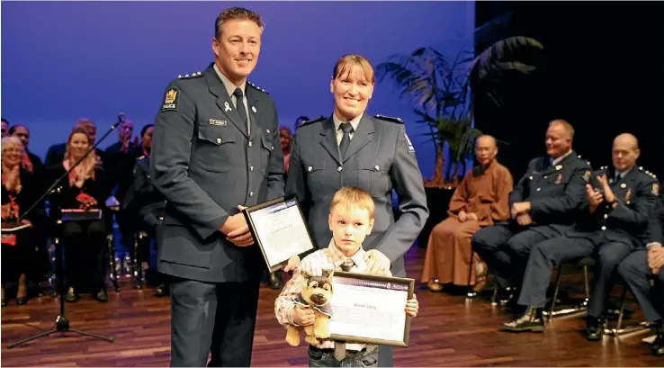  ?? PHOTO: JARRED WILLIAMSON ?? Constable Tineke Laing, right, and her 6-year-old son Ronan accept their awards from Inspector Jason Hewett.