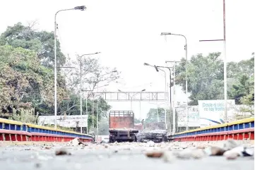  ??  ?? Picture of the three aid trucks which were set ablaze on the Venezuelan side of the Simon Bolivar Internatio­nal Bridge in San Antonio del Tachira, as seen from across the border in Cucuta, Colombia. — AFP photos