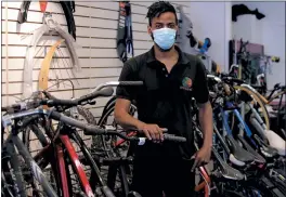  ?? CHARLES KRUPA — THE ASSOCIATED PRESS ?? On June 24, Noah Hicks, owner of Spokehouse Bikes in the Upham’s Corner neighborho­od of Boston, is seen at his shop.