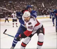  ?? CP PHOTO ?? Ottawa Senators defenceman Erik Karlsson (front) fends of Toronto Maple Leafs centre Zach Hyman during NHL action in Toronto on Feb. 18.