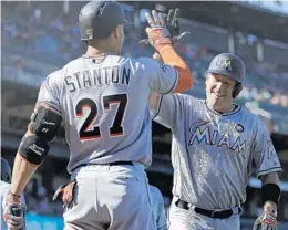  ?? BEN MARGOT/AP ?? A.J. Ellis, right, celebrates with Giancarlo Stanton after hitting a two-run home run off Giants pitcher George Kontos in the 11th inning.