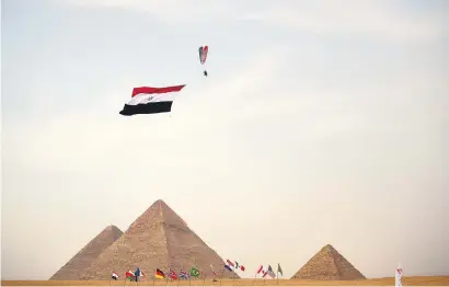  ?? Picture: AFP ?? A paramotor pilot hauls the Egyptian flag above the great pyramids of Giza during an air show in Cairo on Saturday.