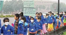  ??  ?? Children wearing air pollution masks attend a demonstrat­ion to spread awareness on the problem of air pollution, on Children’s Day in New Delhi on Tuesday