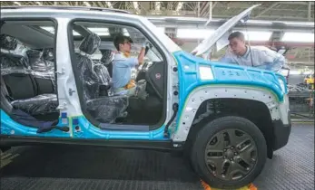  ?? TAN QINGJU / FOR CHINA DAILY ?? GAC Group Employees assemble a car at its plant in Guangzhou, capital of Guangdong province.