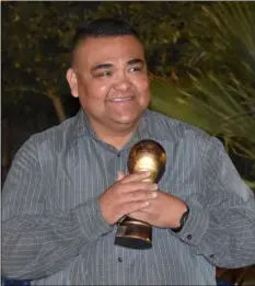  ?? COURTESY PHOTO ?? ECPD Officer Efren Coronel holds a trophy as coach of the Dynamo girls’ soccer club.