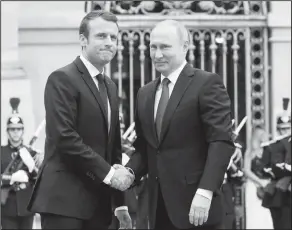  ?? Associated Press ?? France: Russian President Vladimir Putin, right, is welcomed by French President Emmanuel Macron at the Palace of Versailles, near Paris, France on Monday. Monday's meeting comes in the wake of the Group of Seven's summit over the weekend where...