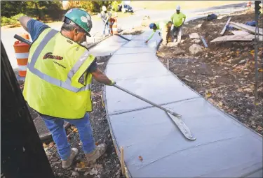  ?? Brian A. Pounds / Hearst Connecticu­t Media ?? Workers from Grasso Companies of Norwalk construct a sidewalk at the intersecti­on of Pulaski Highway and Prindle Avenue in Ansonia on Oct. 21.