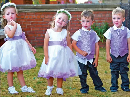  ??  ?? Happy helpers: Amelia, Sofia, Roman and Aston Davies all dressed up as bridesmaid­s and pageboys for their parents