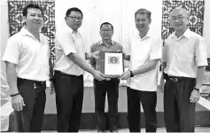  ??  ?? Shu Ying (centre) witnessing the handing over of duties by Lim (second right) to Chee at the Moyog divisional conference.