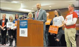  ?? Bill Dentzer Las Vegas Review-journal ?? Nevada Attorney General Aaron Ford stands with supporters Tuesday as he announces that he is taking action in the Question 1 lawsuit from 2017. Voters approved Question 1, the Background Check Initiative, in 2016.