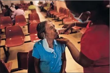  ?? ?? Mudiyanseg­e Chandrawat­hi, a cancer patient, drinks a beverage June 3 after attending a medical clinic at the national cancer hospital in Maharagama, Sri Lanka.