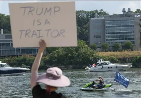  ?? Emily Matthews/Post-Gazette photos ?? Participan­ts in the “4th of July Trump Team PA Boat Parade and MAGA Rally” get their boats ready while others protest the event on Saturday near the Hot Metal Bridge on the South Side.