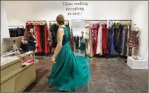  ?? MEL MELCON / LOS ANGELES TIMES ?? Edie Fasano tries on an evening gown this month at Rent the Runway in Woodland Hills, Calif. At left is stylist Shannon Carpenter. The store is more a showroom than a shop.