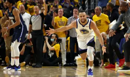  ?? Harry How, Getty Images ?? Stephen Curry of the Golden State Warriors reacts after a three point basket against the Dallas Mavericks on Friday night.