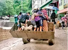  ?? ?? Residents evacuated on a backhoe loader in Muguthang, Sikkim. (AFP / Indian Ministry of Defence)