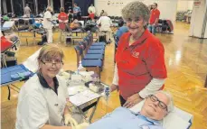  ?? FOTO: WALTER SCHMID ?? Horst Bentele auf der Liege wird von einer examiniert­en Schwester des Blutspende­dienstes und von Hilde Hägele von der Ortsgruppe Isny betreut.