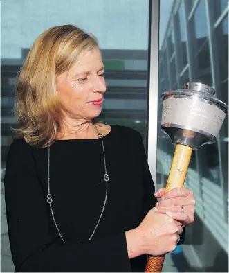  ?? JIM WELLS ?? Mary Moran, CEO of Calgary 2026, holds a 1988 Olympic Torch during the Celebratio­n of Sport 2018 held at Winsport on Thursday where addressed about the benefits of hosting the 2026 Olympics.