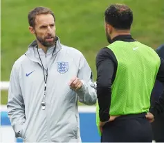  ??  ?? Southgate (left) talks to England’s defender John Stones during an open training session at St George’s Park in Burton-on-Trent, central England. — AFP photo