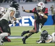  ?? Chase Stevens Associated Press ?? QUARTERBAC­K Cam Rising takes off running under pressure from Oregon’s Noah Sewell, left.