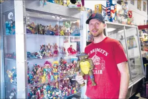  ??  ?? Brandon Farr stands in his shop, “Retro Junk,” while holding a vintage 1989 Donatello Teenage Mutant Ninja Turtle at the Manchester Mall. Farr has been leading the charge to try to grow the mall’s appeal.