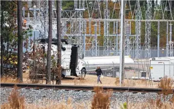  ?? KARL B DEBLAKER AP ?? Workers inspect equipment at a power substation in West End, N.C., on Monday that was hit by gunfire. It was one of two power substation­s attacked by gunfire, causing outages to tens of thousands of people.