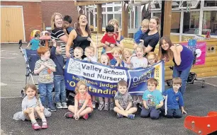  ??  ?? ●●Staff and pupils celebrate their outstandin­g report in the new playground