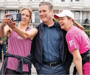  ?? ?? Labour leader Sir Keir Starmer meets two runners on Worthing sea front in East Sussex whilst out campaignin­g yesterday