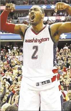  ?? AP ?? John Wall jumps on scorer’s table to celebrate Wizards’ comefrom-behind 92-91 Game 6 win against Celtics on Friday.