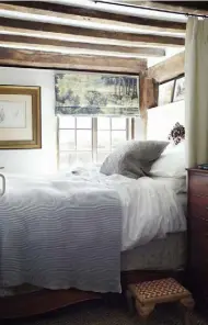  ??  ?? THIS PAGE, FROM ABOVE LEFT The tiny guest bedroom is dominated by an ornate French bed; the Victorian rolltop bath was re-enamelled and painted to match the bathroom walls; awirework chandelier makes an eye-catching focal point in one of the oast-house bedroomsOP­POSITE Cladding and seagrass flooring creates a restful, rustic look in the master bedroom