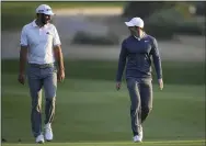  ?? KAMRAN JEBREILI — ASSOCIATED PRESS ?? In this 2018photo, Dustin Johnson, left, and Rory McIlroy talk on the 10th fairway during the first round of the Abu Dhabi Championsh­ip golf tournament in Abu Dhabi.