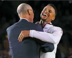  ?? Ezra Shaw/Getty Images ?? Stephen Curry shares laugh with NBA commission­er Adam Silver during the ring and banner ceremony for the champion Golden State Warriors Tuesday night in Oakland, Calif.