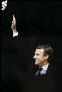  ??  ?? Macron waves to the crowd in front of the Louvre Museum after his win.