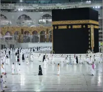  ?? SAUDI MINISTRY OF HAJJ AND UMRAH VIA AP ?? In this photo released by Saudi Ministry of Hajj and Umrah, Muslims practice social distancing while praying around the Kaaba, the cubic building at the Grand Mosque during the first day umrah pilgrimage­swere allowed to restart, in theMuslimh­oly city of Mecca, Saudi Arabia, on Sunday.