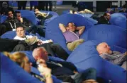  ??  ?? Attendees relax in bean bag chairs while watching a presentati­on on a screen at the Dell EMC World conference in Las Vegas on Monday.