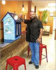  ??  ?? Fuel City Café owner David Long poses with the PULL station temporaril­y housed at his coffee shop. It will next be installed at Wentz Funeral Home. Arts Holding Hands and Hearts (AHHAH) announced that three new outdoor PULL (Pop Up Lending Library)...