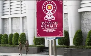  ?? —AP ?? Coming soon: Thai policemen walking past a banner promoting the Asean summit in Nonthaburi province.