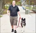  ?? Peter Hvizdak / Hearst Connecticu­t Media ?? In this file photo, Bradford Cole of Milford, K9 First Responders’ executive director, walks Niko, his Akita breed dog, along the West Haven beach boardwalk. Cole is a believer in using 6-foot leashes that enable the dog handler to control their dog in unpredicta­ble environmen­ts.