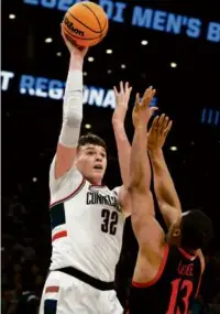  ?? DANIELLE PARHIZKARA­N/GLOBE STAFF ?? UConn’s 7-foot-2-inch center Donovan Clingan (8 points) shoots over San Diego State’s Jaedon LeDee during the second half.