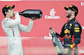  ?? — MARK THOMPSON/GETTY IMAGES ?? Race winner Daniel Ricciardo of Australia, right, celebrates his win on the podium with third-place finisher Lance Stroll of Canada at the Azerbaijan Formula One GP on Sunday.