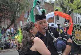  ?? RJ SMITH FOR THE SAVANNAH MORNING NEWS ?? A parade goer plants a smooch on the cheek of a bagpiper from the LA Police Emerald Society during the Savannah St. Patrick's Day Parade on Saturday.