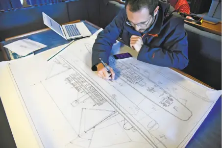  ?? Photos by Michael Short / Special to The Chronicle ?? U.S. Navy archaeolog­ist Alexis Catsambis writes data on a large diagram about the fishing vessel Ituna, which sank in 1920.