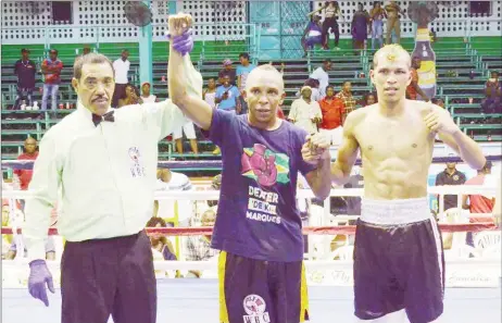  ??  ?? Dexter ‘De Kid’ Marques with his hands raised by referee, Eion Jardine delivered a whirlwind performanc­e and pounded out a unanimous decision victory against Dionis ‘El Flaco’ Arias (6-10-2) of Venezuela. (Orlando Charles photo)
