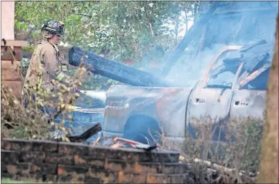  ?? [DORAL CHENOWETH III/THE ASSOCIATED PRESS] ?? Even after firefighte­rs were made aware of the risks caused by smoldering remains, a Columbus firefighte­r neglects to wear his breathing apparatus while extinguish­ing a fire at a Pickard Road home on July 24, 2017.