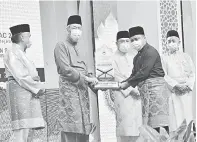  ??  ?? QARI: Juara qari Mohd Ayub Maidi menerima hadiah daripada Tun Juhar.