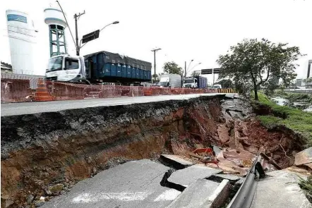  ?? Rivaldo Gomes/Folhapress ?? » ÁGUA VEM Margem do rio Tamanduate­í desmorona e engole faixa da avenida dos Estados, em Santo André (Grande SP) no último domingo (14); rede de abastecime­nto foi afetada e região ficou sem água, mas ninguém ficou ferido