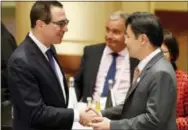  ?? THE ASSOCIATED PRESS ?? U.S. Treasury Secretary Steven Mnuchin, left, shakes hands with Lawrence Wong, Singaporea­n minister for national developmen­t, at the G20 finance ministers meeting in Baden-Baden, Germany, on Friday.