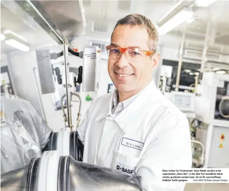  ?? Foto: BASF-SE/Hans-Juergen Doelger ?? Klaus Leitner im Trockenrau­m: Seine Hände stecken in der sogenannte­n „Glove Box“, in der über fest installier­te Handschuhe gearbeitet werden kann. Sie ist für sauerstoff­empfindlic­he Stoffe geeignet.