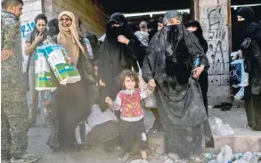  ?? — AFP ?? Syrian women and children gather on the western front after fleeing the centre of Raqa.